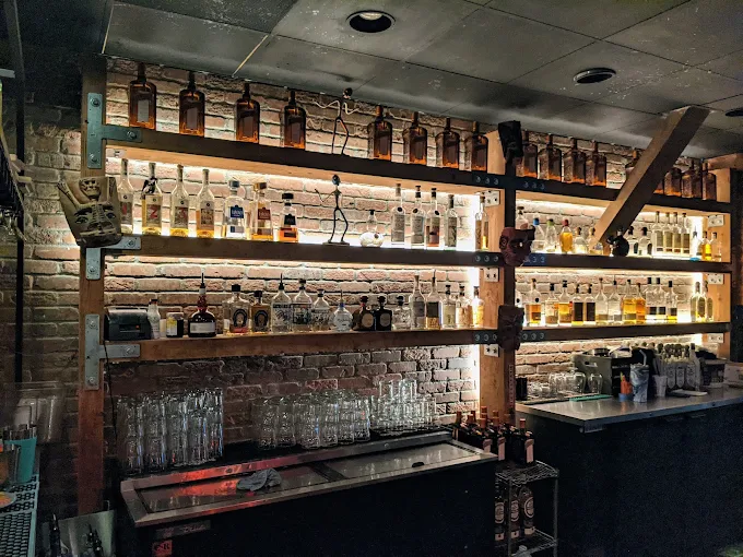 Backlit tequila shelves behind the Machete bar