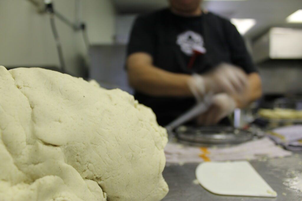 A cook pressing masa into tortillas in the Machete kitchen